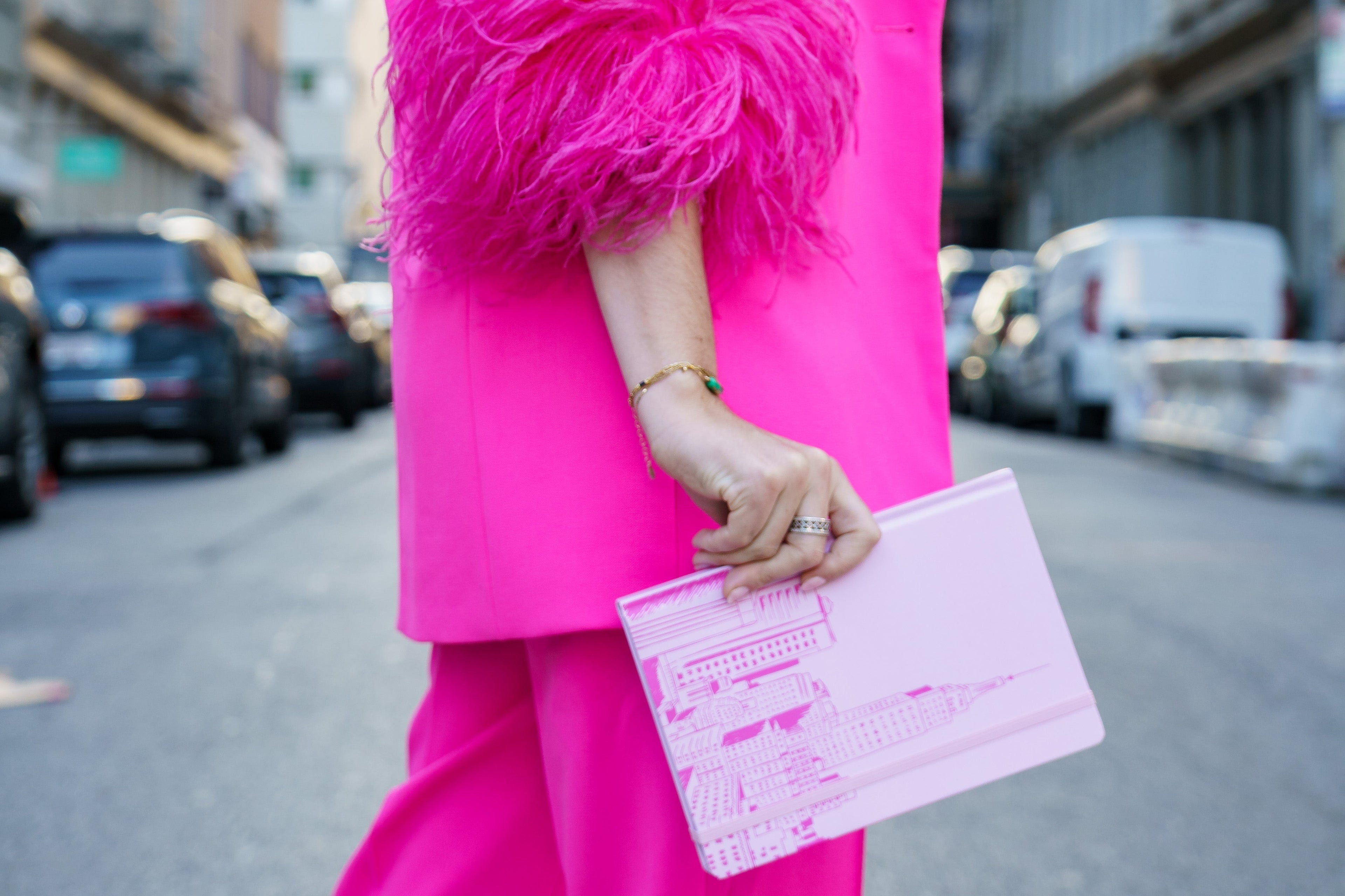 woman holding cityscape pink journal