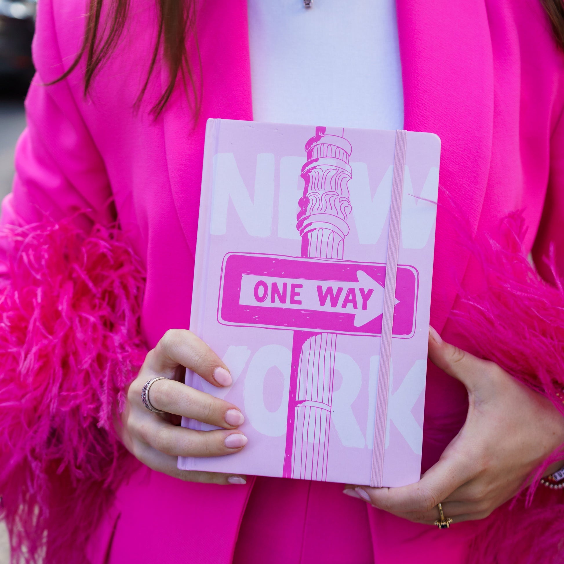 woman holding one way sign pink journal